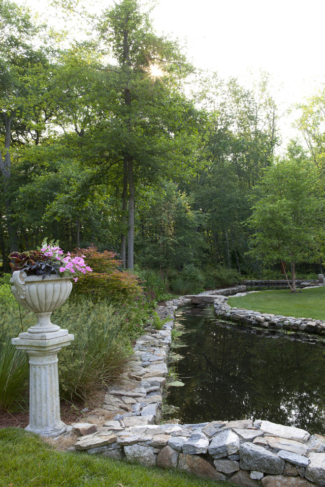 Foto de jardín clásico grande en patio trasero con jardín francés, estanque, exposición parcial al sol y gravilla