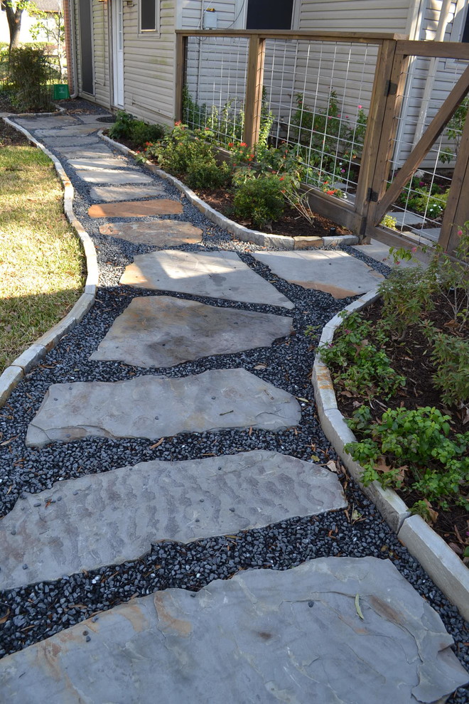 This is an example of a modern back formal partial sun garden in Houston with gravel.