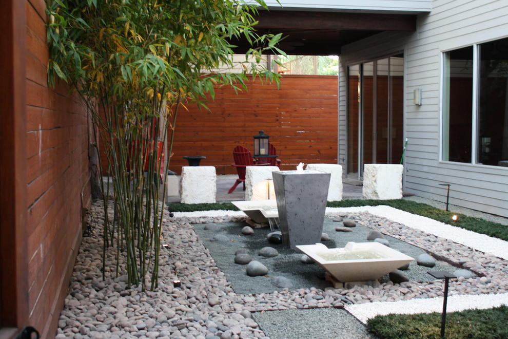 Cette image montre un jardin arrière design avec un point d'eau, une exposition ombragée et du gravier.