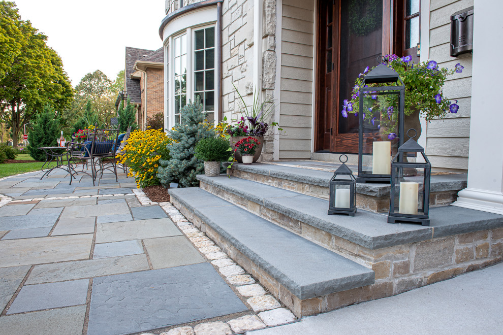 This is an example of a mid-sized traditional full sun front yard stone walkway in Milwaukee for summer.