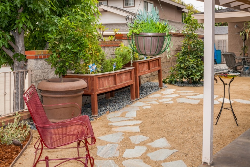На фото: солнечный засухоустойчивый сад среднего размера на заднем дворе в стиле фьюжн с хорошей освещенностью, покрытием из каменной брусчатки и пустынными растениями с