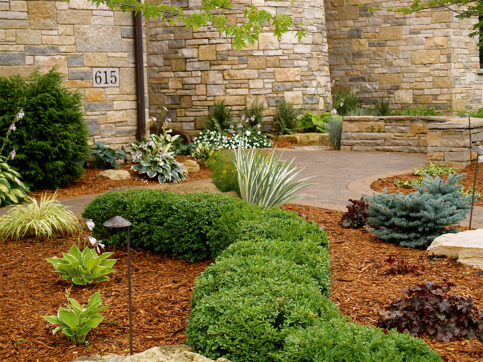 This is an example of a large traditional full sun backyard concrete paver landscaping in Minneapolis.
