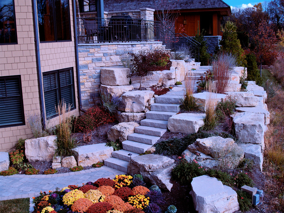 Photo of a large traditional full sun backyard concrete paver landscaping in Minneapolis.