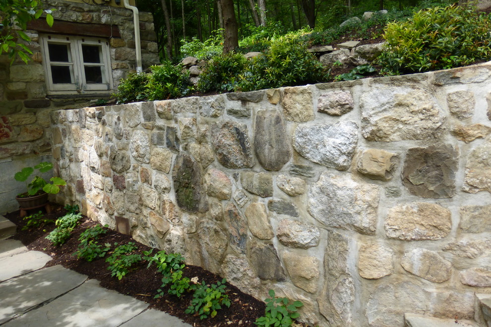 Photo of a large rustic drought-tolerant and partial sun front yard stone retaining wall landscape in New York for summer.