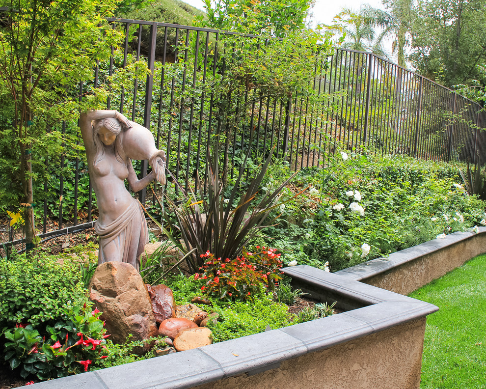 Mittelgroße, Halbschattige Eklektische Gartenmauer im Sommer, hinter dem Haus in Orange County