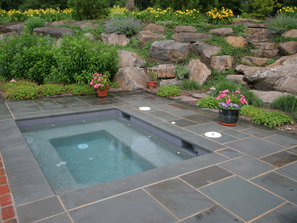 Esempio di un giardino minimalista esposto in pieno sole di medie dimensioni e dietro casa in estate con fontane e pavimentazioni in mattoni