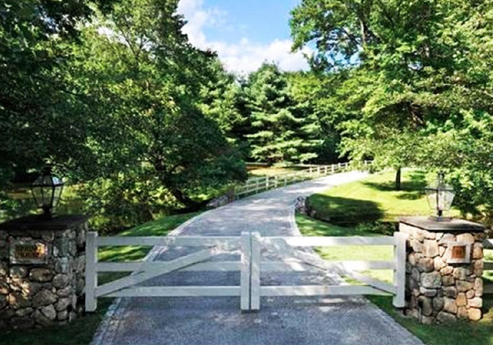 This is an example of a huge farmhouse front yard gravel driveway in New York.