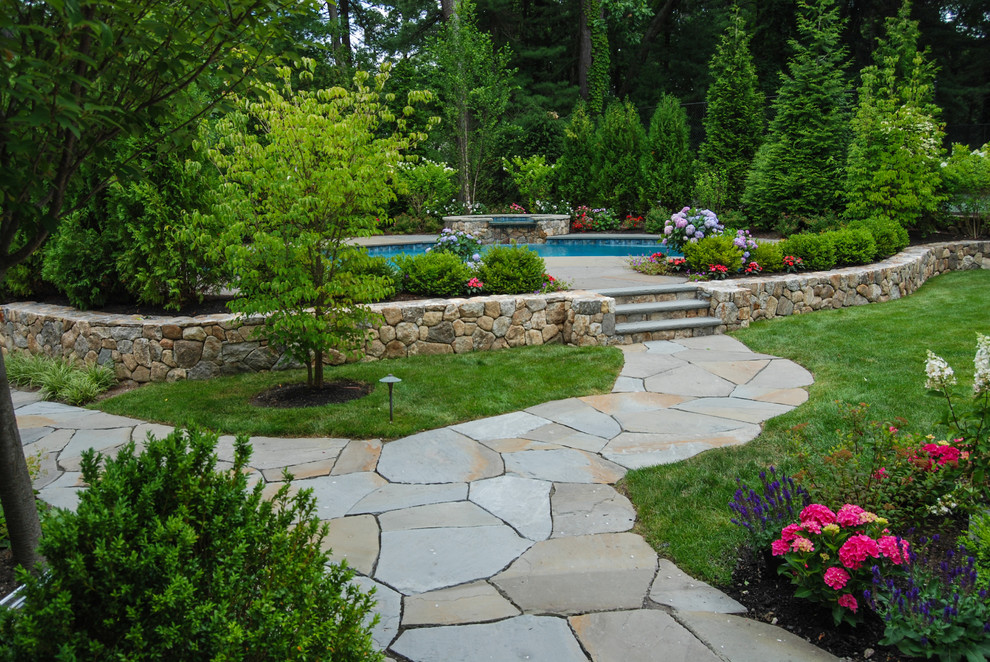 Foto di un grande giardino classico esposto in pieno sole dietro casa con pavimentazioni in pietra naturale