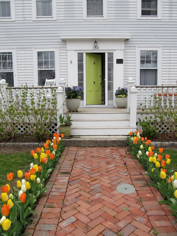 Medium sized farmhouse front full sun garden for spring in Boston with brick paving.