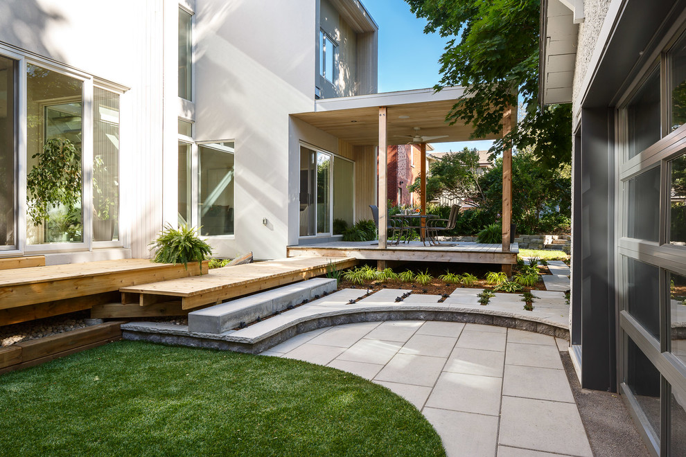 Inspiration for a mid-sized contemporary drought-tolerant and full sun backyard landscaping in Ottawa with decking.