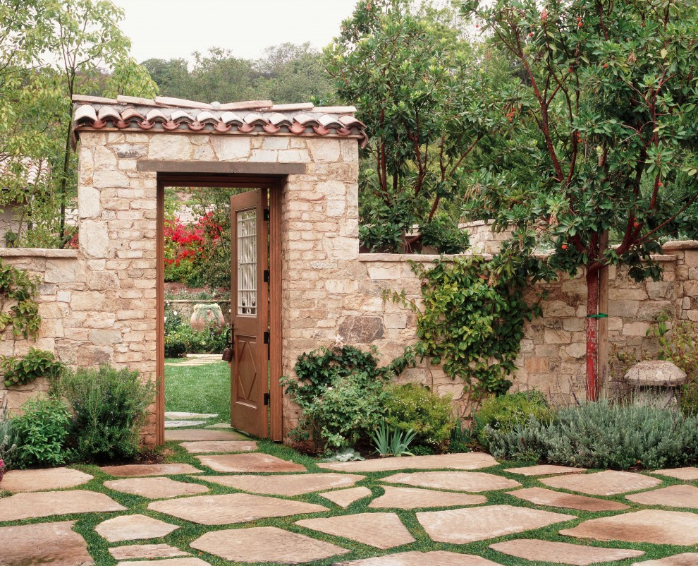 Imagen de jardín clásico en patio trasero con adoquines de piedra natural