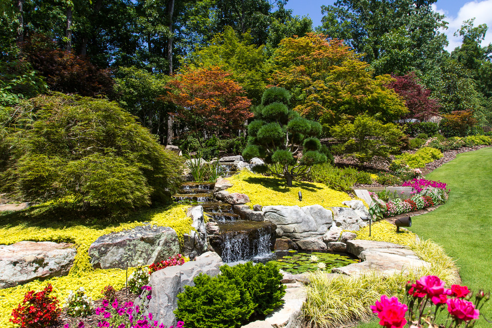 Immagine di un giardino contemporaneo esposto in pieno sole di medie dimensioni e dietro casa in primavera con fontane e pavimentazioni in pietra naturale