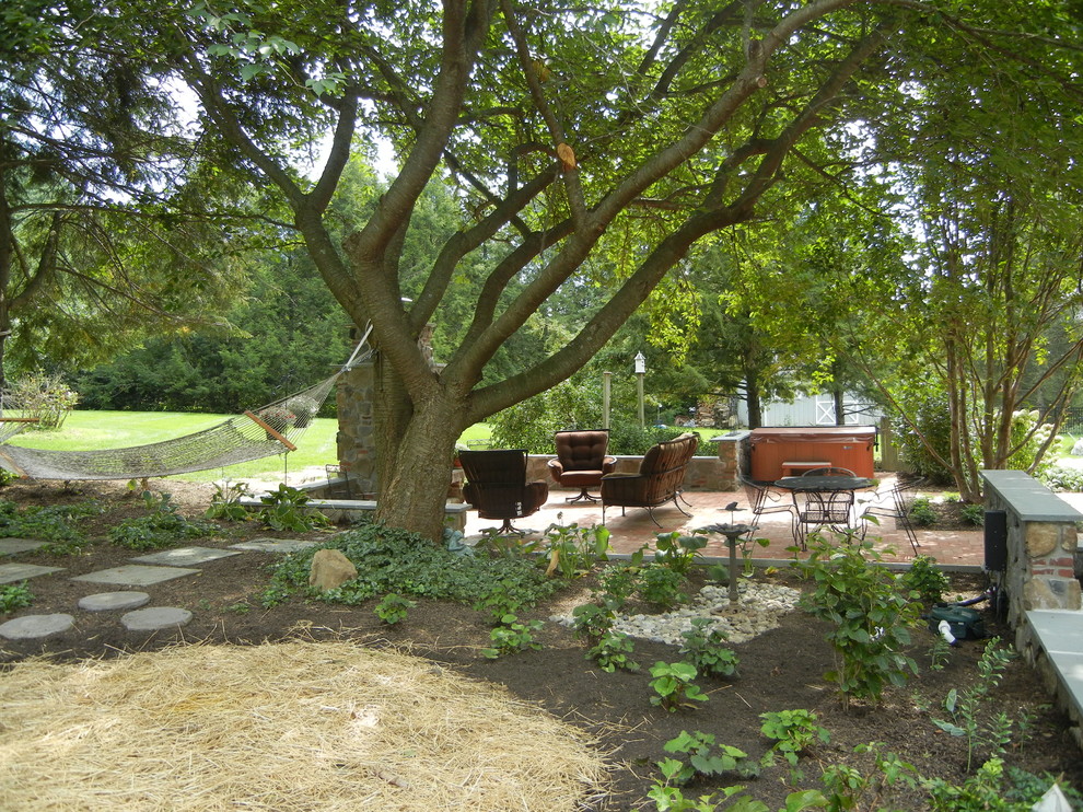 Immagine di un giardino xeriscape tradizionale in ombra di medie dimensioni e dietro casa in primavera con un caminetto e pavimentazioni in pietra naturale