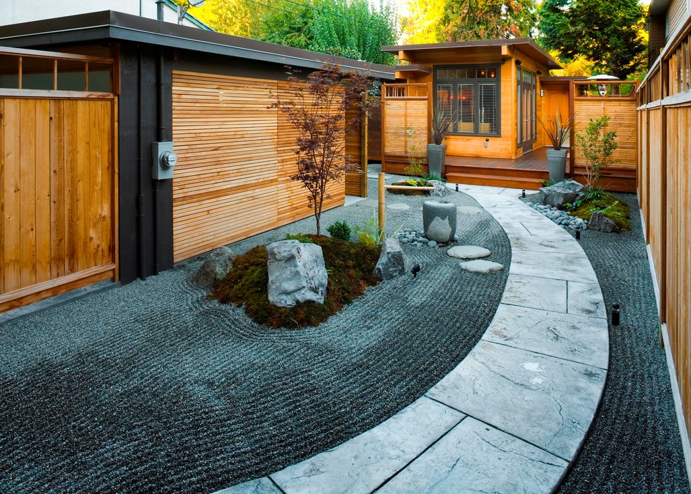 Inspiration for a large asian partial sun courtyard stone landscaping in Vancouver.