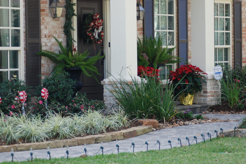 Design ideas for a large traditional front partial sun garden in Houston with brick paving.
