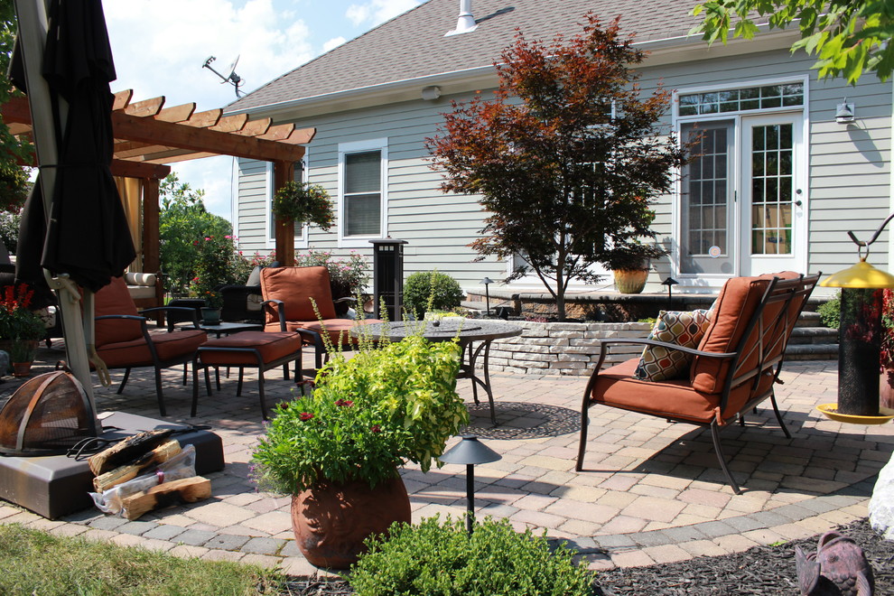 Inspiration for a mid-sized transitional full sun backyard brick formal garden in Columbus with a pergola for spring.