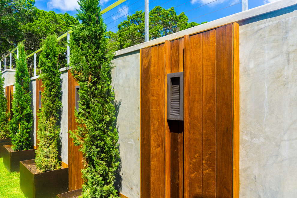 Foto de jardín minimalista de tamaño medio en patio con muro de contención, exposición parcial al sol y entablado