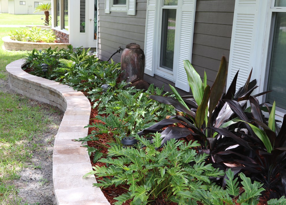 Foto di un giardino stile marinaro esposto a mezz'ombra di medie dimensioni e davanti casa con un muro di contenimento e pavimentazioni in cemento