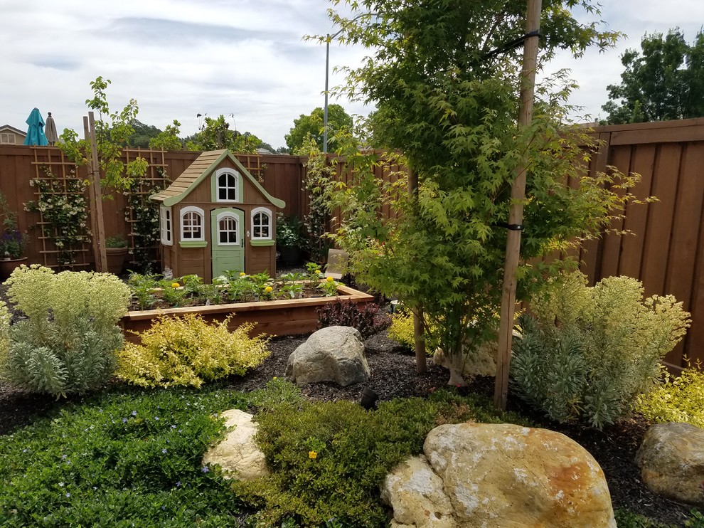 Kleiner, Halbschattiger Shabby-Look Garten im Frühling, hinter dem Haus mit Spielgerät und Betonboden in Sacramento