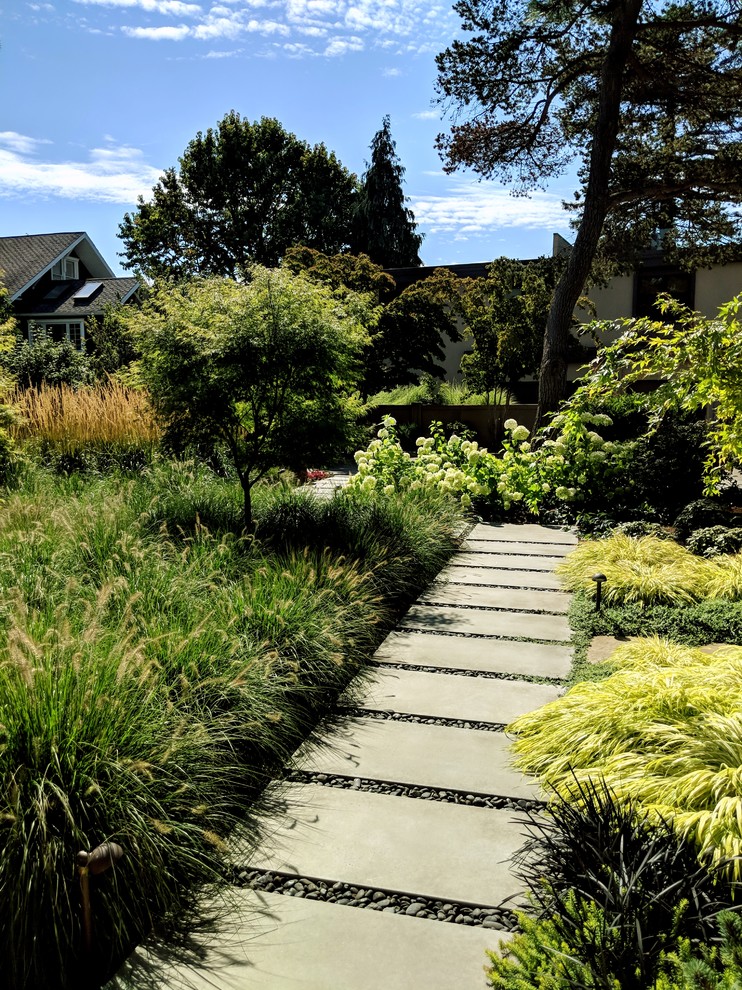 Ispirazione per un giardino minimalista esposto in pieno sole davanti casa in estate con pavimentazioni in cemento e un ingresso o sentiero