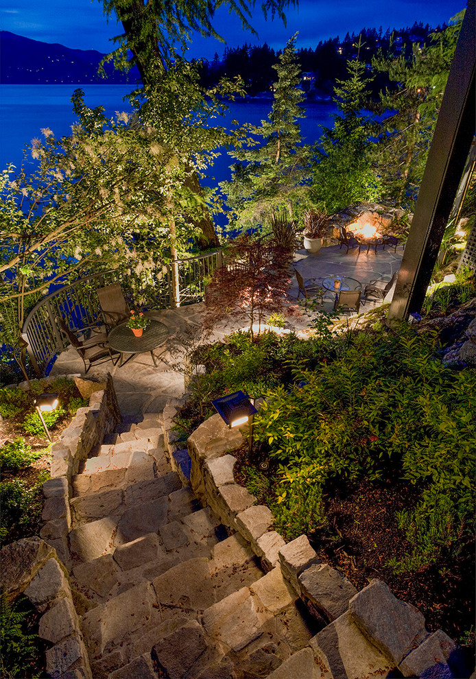 Photo of a medium sized rustic sloped partial sun garden for summer in Vancouver with a fire feature and natural stone paving.