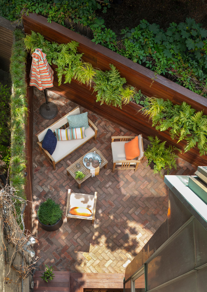 Inspiration for a small contemporary backyard brick landscaping in New York.