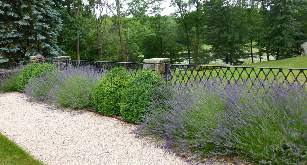 Idée de décoration pour un très grand jardin à la française arrière tradition l'été avec une exposition ensoleillée et du gravier.