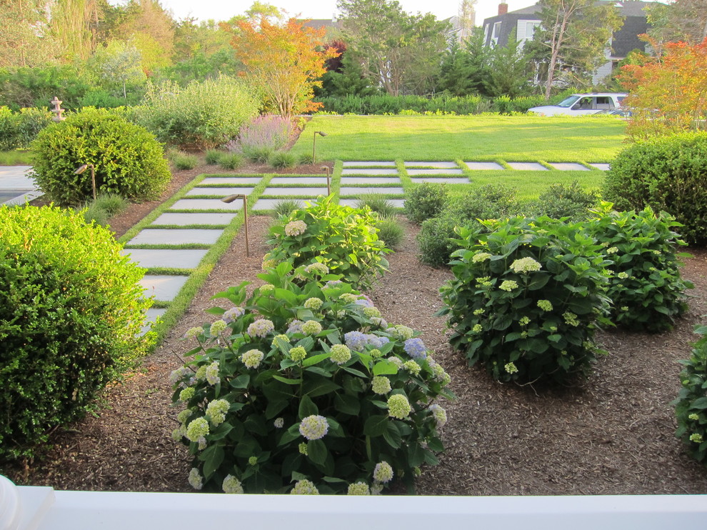 Cette image montre un aménagement d'entrée ou allée de jardin arrière minimaliste de taille moyenne avec une exposition partiellement ombragée et des pavés en pierre naturelle.