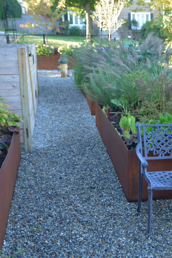 Aménagement d'un petit jardin potager latéral classique avec une exposition partiellement ombragée et du gravier.