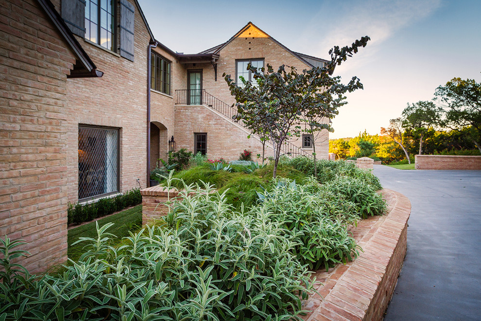 Inspiration for a large rural front formal full sun garden for spring in Austin with a garden path and concrete paving.
