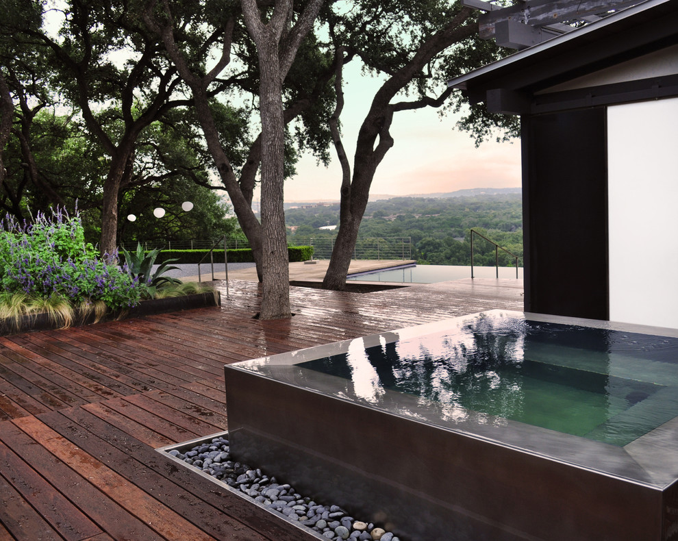 This is an example of a large modern backyard landscaping in Austin.