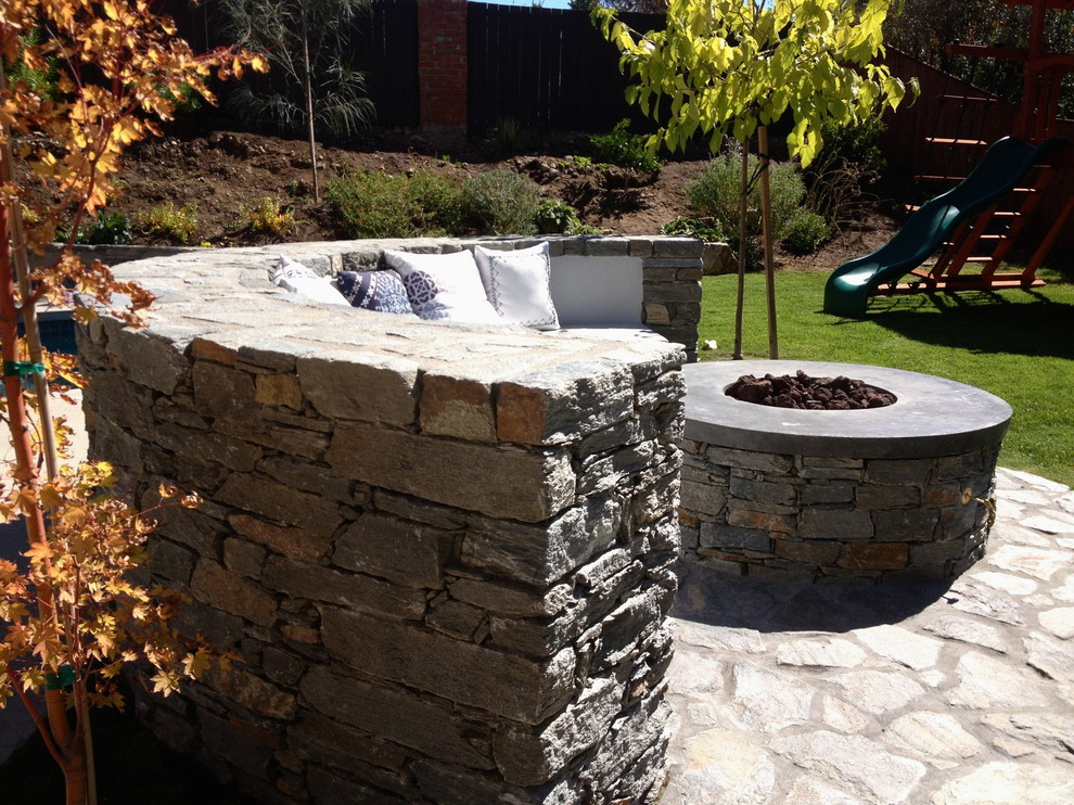 Design ideas for a large contemporary back full sun garden for summer in Los Angeles with natural stone paving.