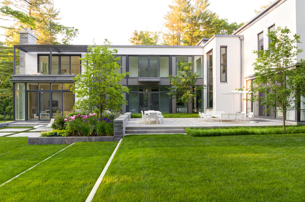 This is an example of a contemporary garden in Boston with natural stone paving.