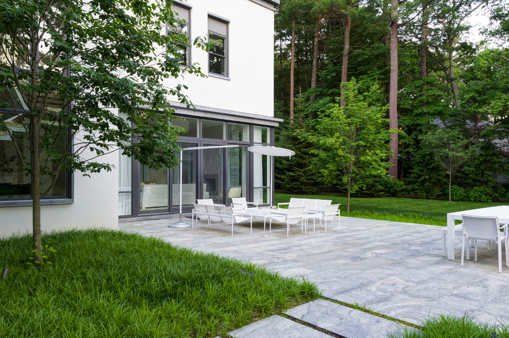 Esempio di un giardino design con pavimentazioni in pietra naturale