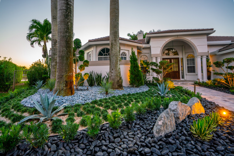 Immagine di un giardino xeriscape minimalista esposto in pieno sole di medie dimensioni e davanti casa con un ingresso o sentiero e pavimentazioni in pietra naturale