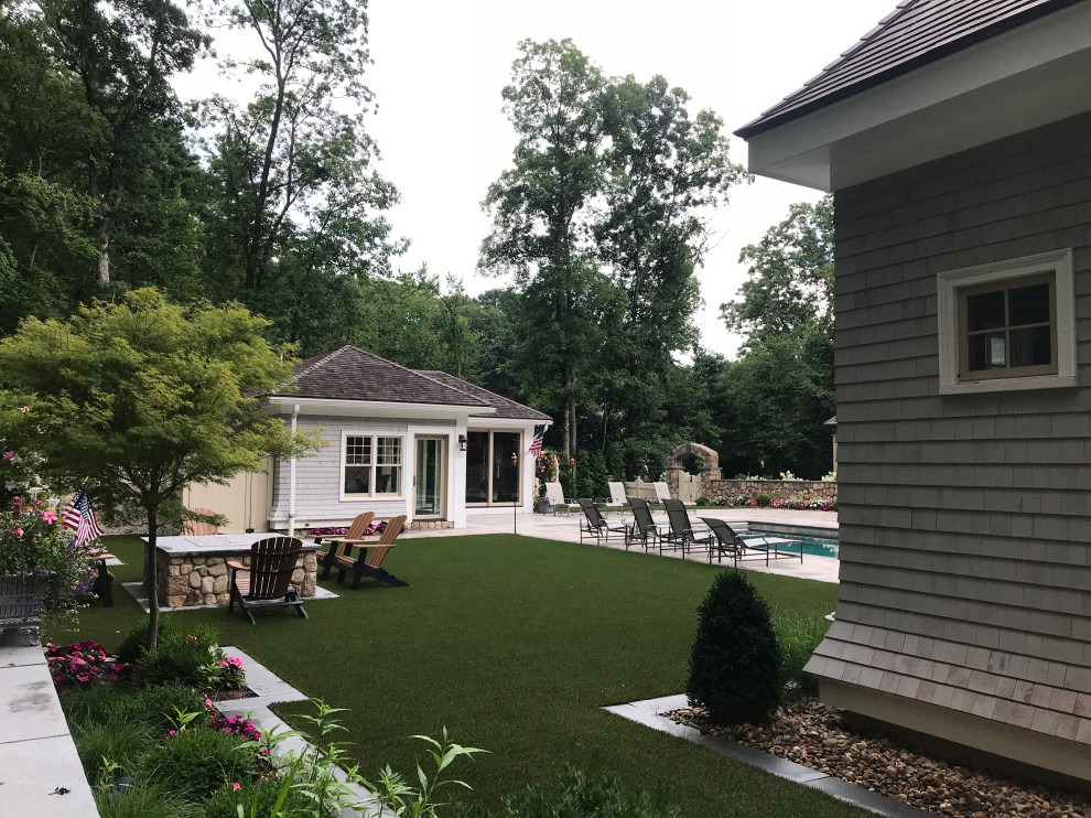 This is an example of an expansive traditional back xeriscape and private full sun garden for summer in Boston with natural stone paving.