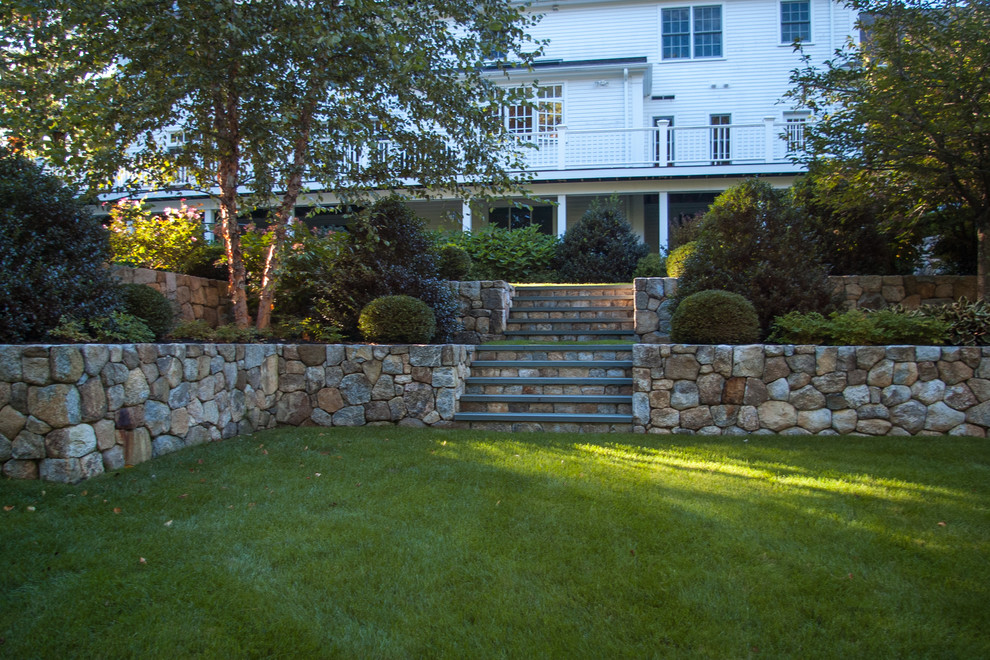 Foto di un grande giardino chic esposto a mezz'ombra dietro casa con un muro di contenimento e pavimentazioni in pietra naturale
