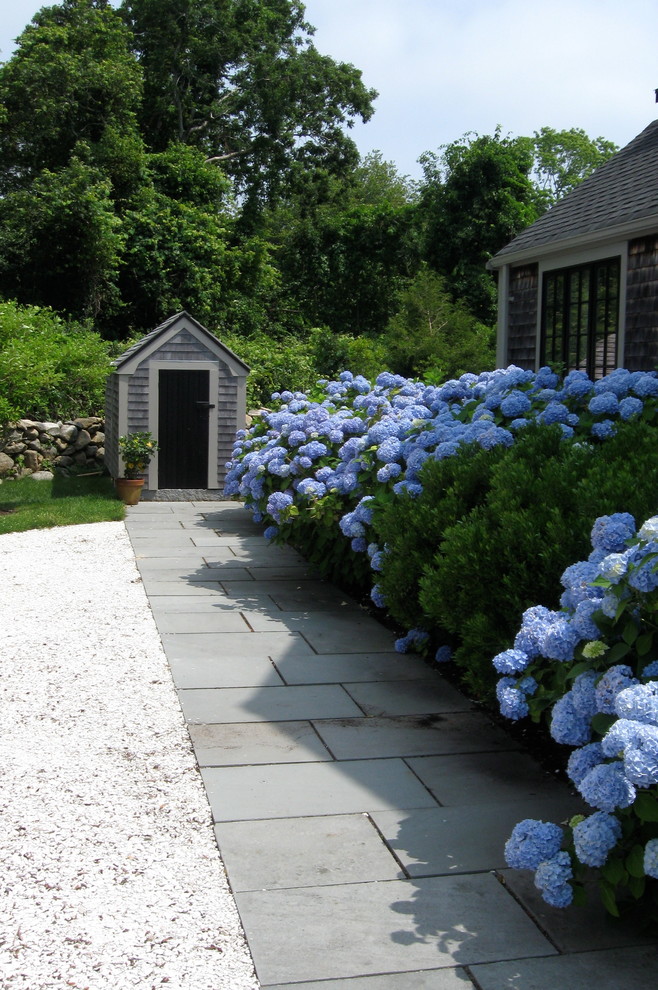 На фото: большой весенний участок и сад на боковом дворе в классическом стиле с подъездной дорогой, полуденной тенью и покрытием из каменной брусчатки с
