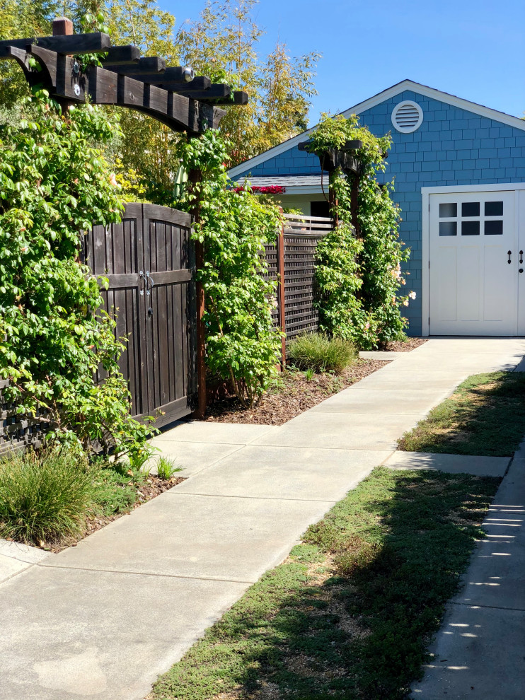 На фото: участок и сад среднего размера на боковом дворе в стиле кантри с подъездной дорогой, садовой дорожкой или калиткой, полуденной тенью и мульчированием