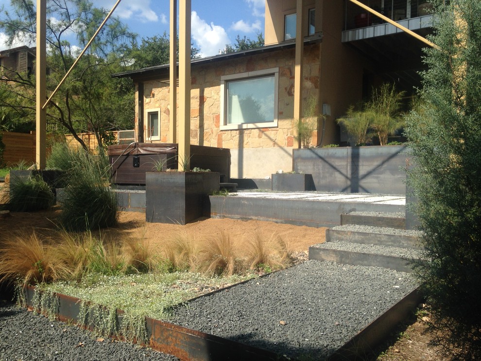 Modelo de jardín de secano minimalista de tamaño medio en verano en patio trasero con muro de contención, exposición parcial al sol y adoquines de piedra natural