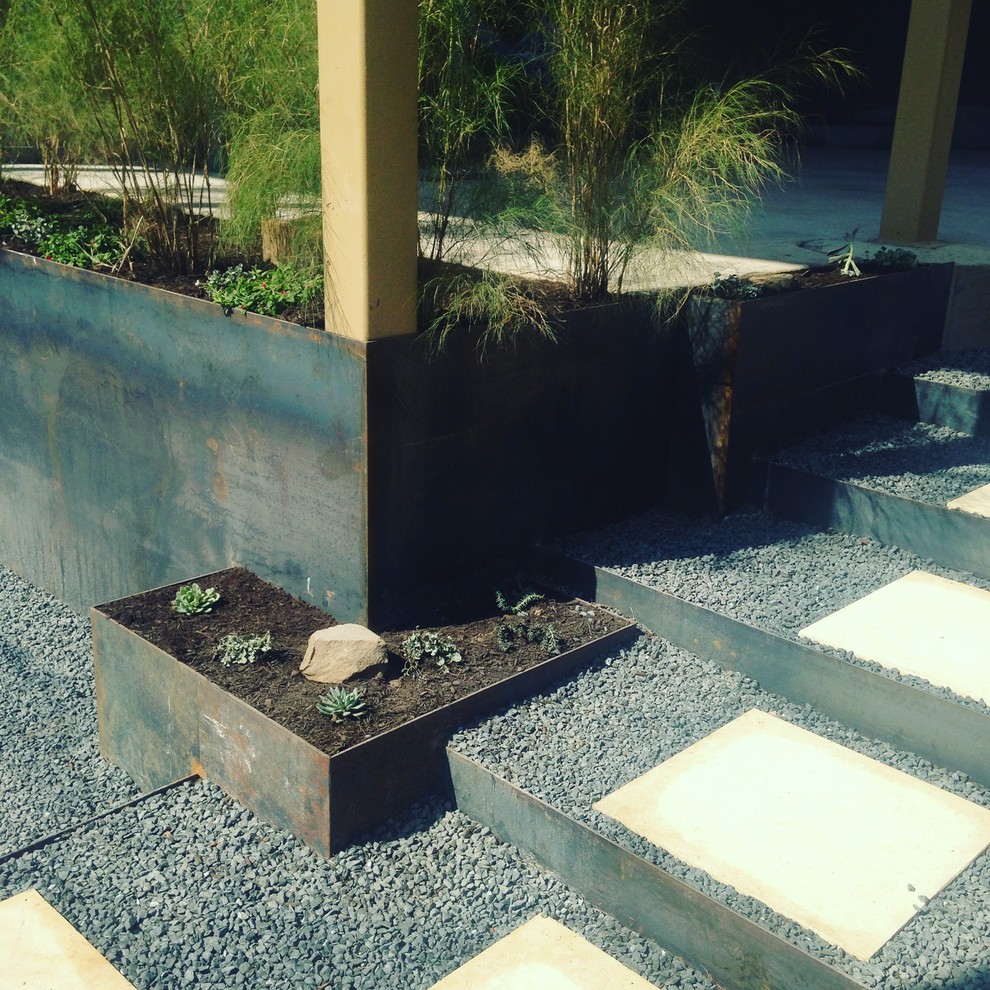 Diseño de jardín de secano minimalista de tamaño medio en verano en patio trasero con muro de contención, exposición parcial al sol y adoquines de piedra natural