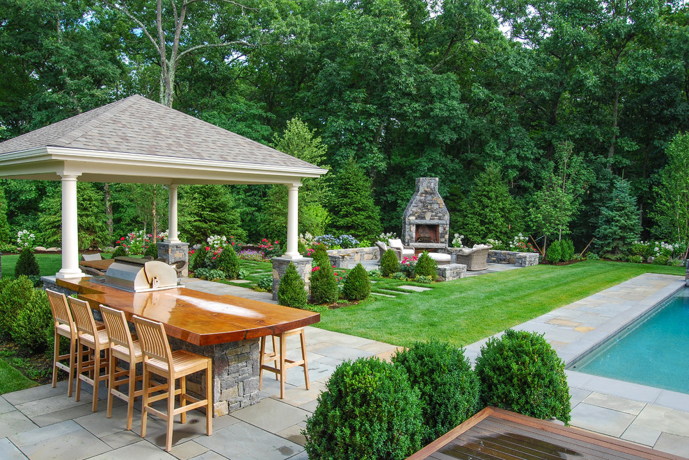 Inspiration for a large traditional full sun backyard stone landscaping in Boston.