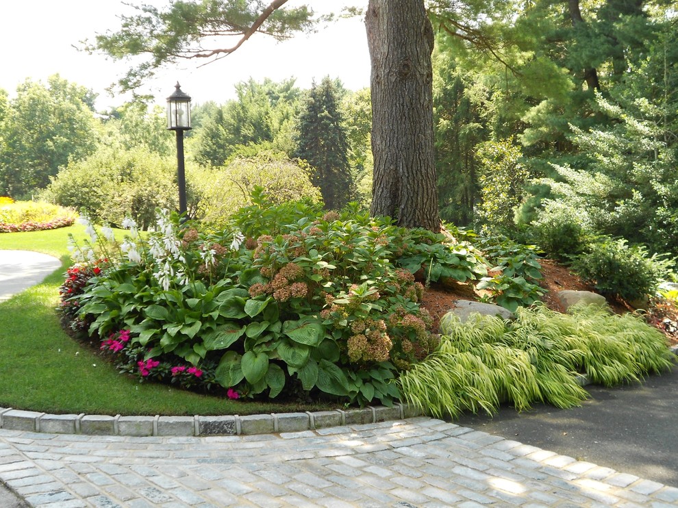 This is an example of a large traditional front partial sun garden for summer in New York.