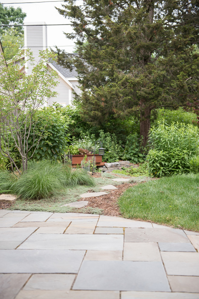 Cette image montre un petit jardin arrière bohème l'été avec une exposition partiellement ombragée et des pavés en pierre naturelle.