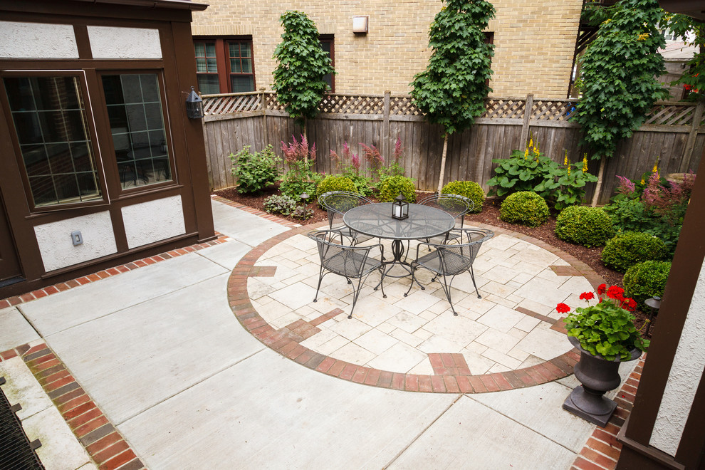 This is an example of a small classic back patio in Milwaukee with natural stone paving.