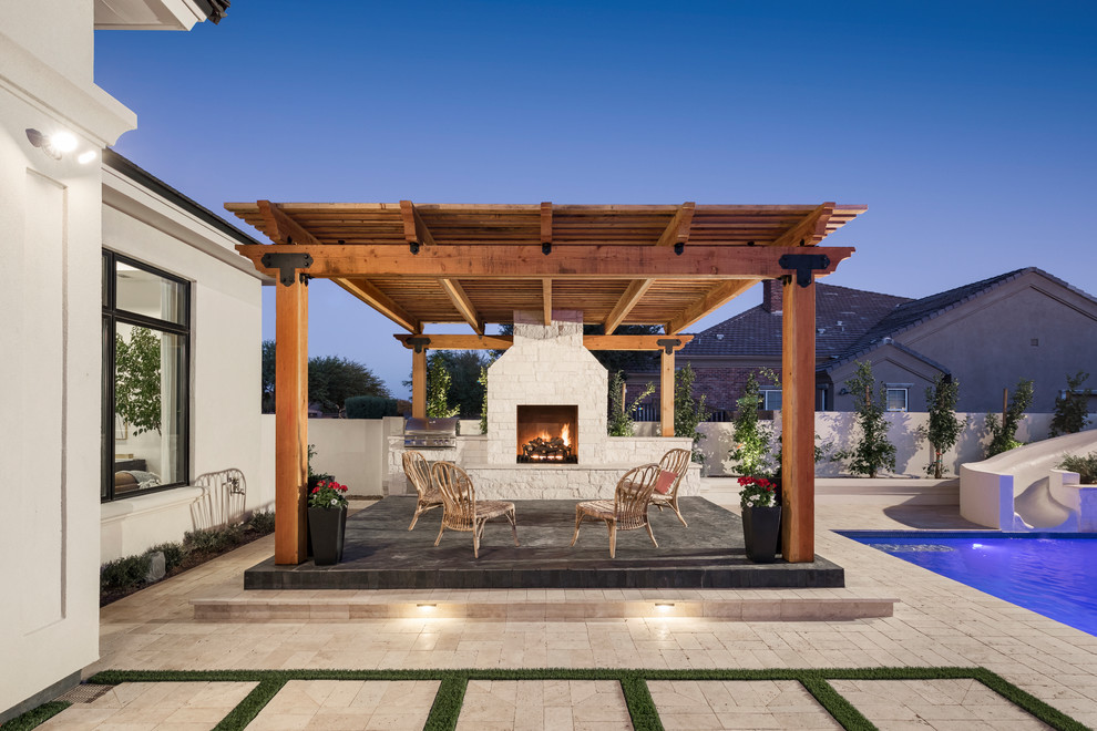 Photo of an expansive traditional back patio in Phoenix with a fire feature and natural stone paving.