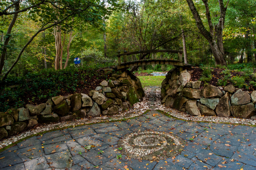 Klassischer Garten hinter dem Haus mit Natursteinplatten und Steindeko in Raleigh