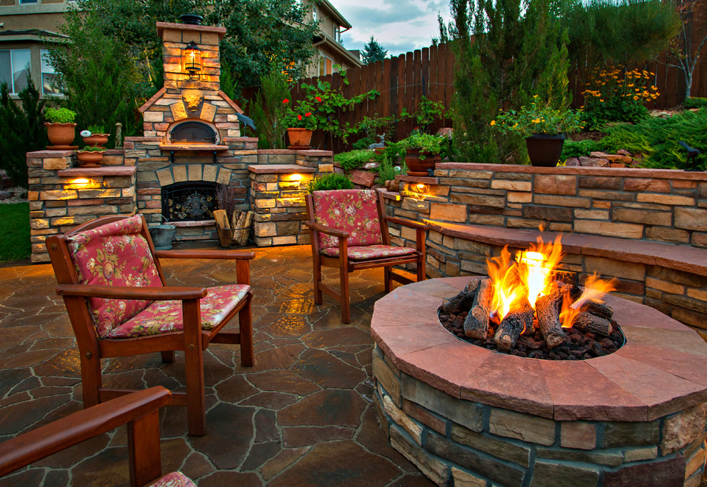 Inspiration for a large rustic back patio in Wichita with a fire feature and natural stone paving.