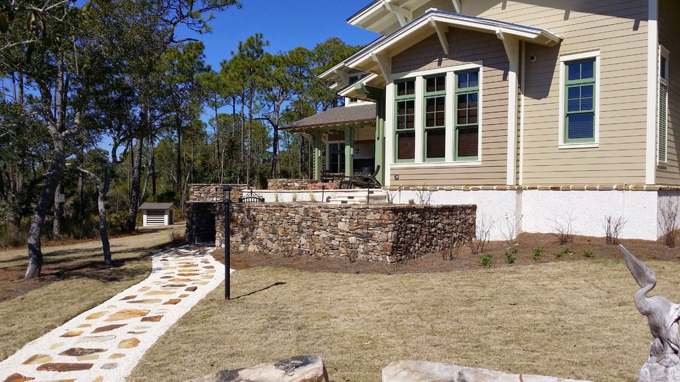 Foto di un grande giardino stile americano esposto in pieno sole dietro casa in primavera con un focolare e pavimentazioni in pietra naturale