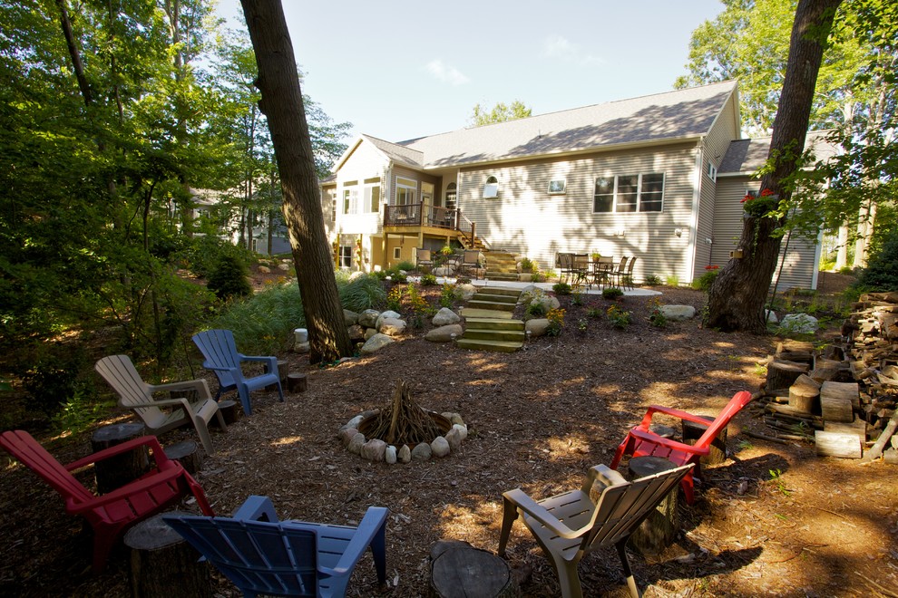 Inspiration for a rustic backyard landscaping in Grand Rapids with a fire pit.